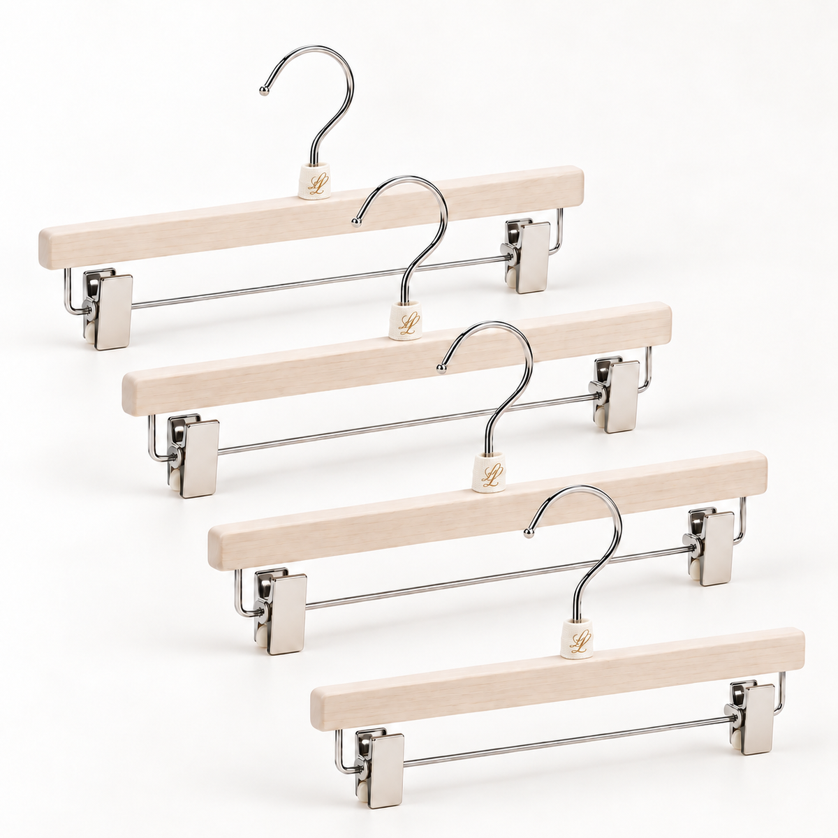 Set of four light ivory wooden trouser and skirt hangers with adjustable chrome clips for coordinated wardrobe organisation.