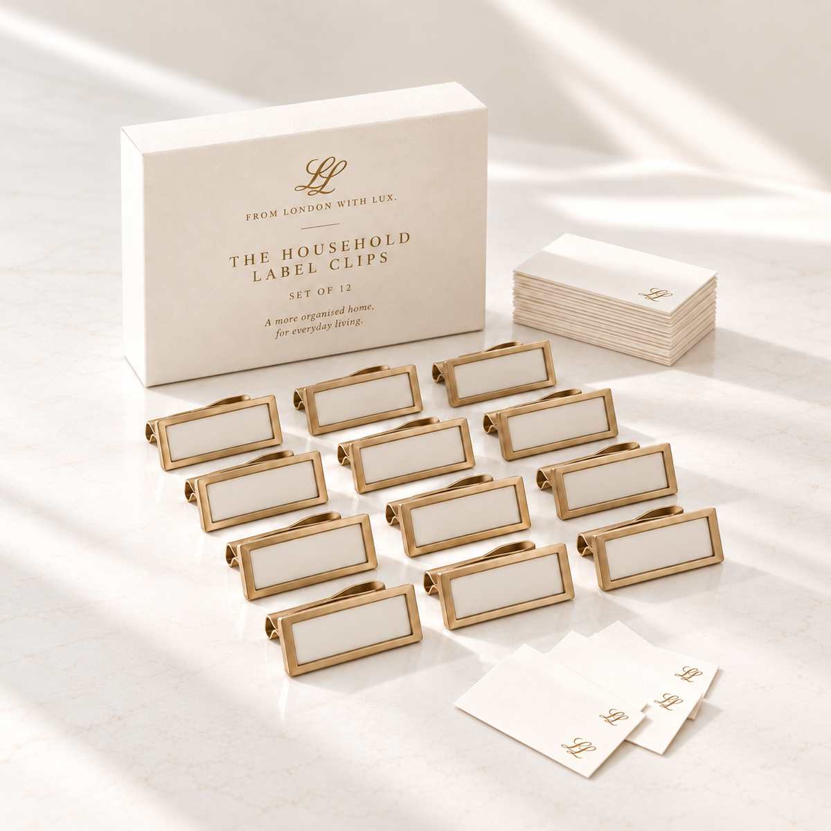 Set of twelve champagne-gold household label clips with warm-ivory cards and matching From London with Lux. presentation packaging.