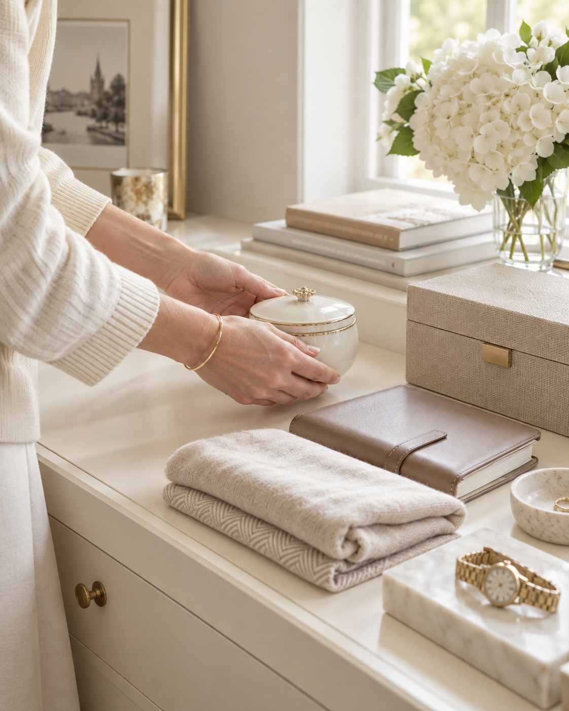 Private home organiser carefully reviewing personal belongings in a bright ivory interior, with decisions about storage and removal handled thoughtfully.
